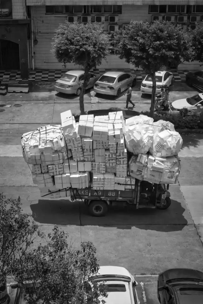 High angle view of a heavily loaded truck navigating a city street.